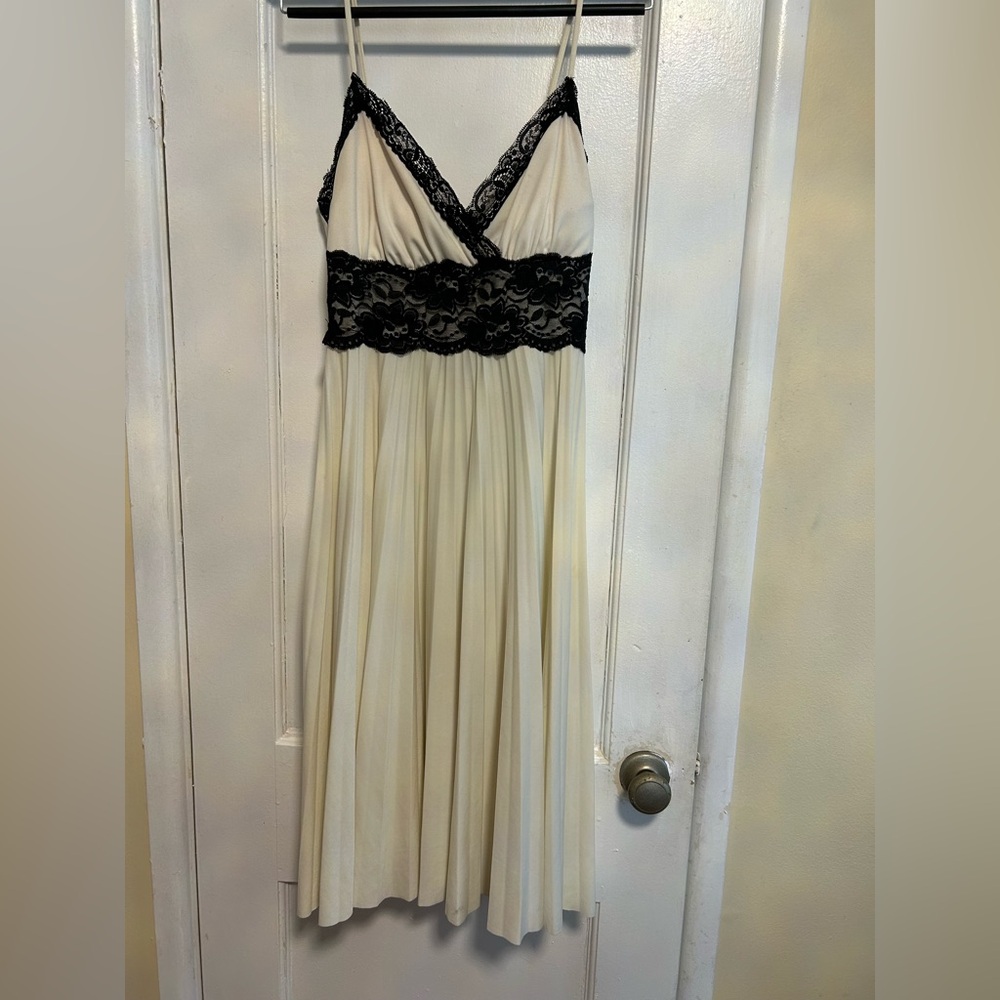 Off white pleated dress with black lace, below the knee length